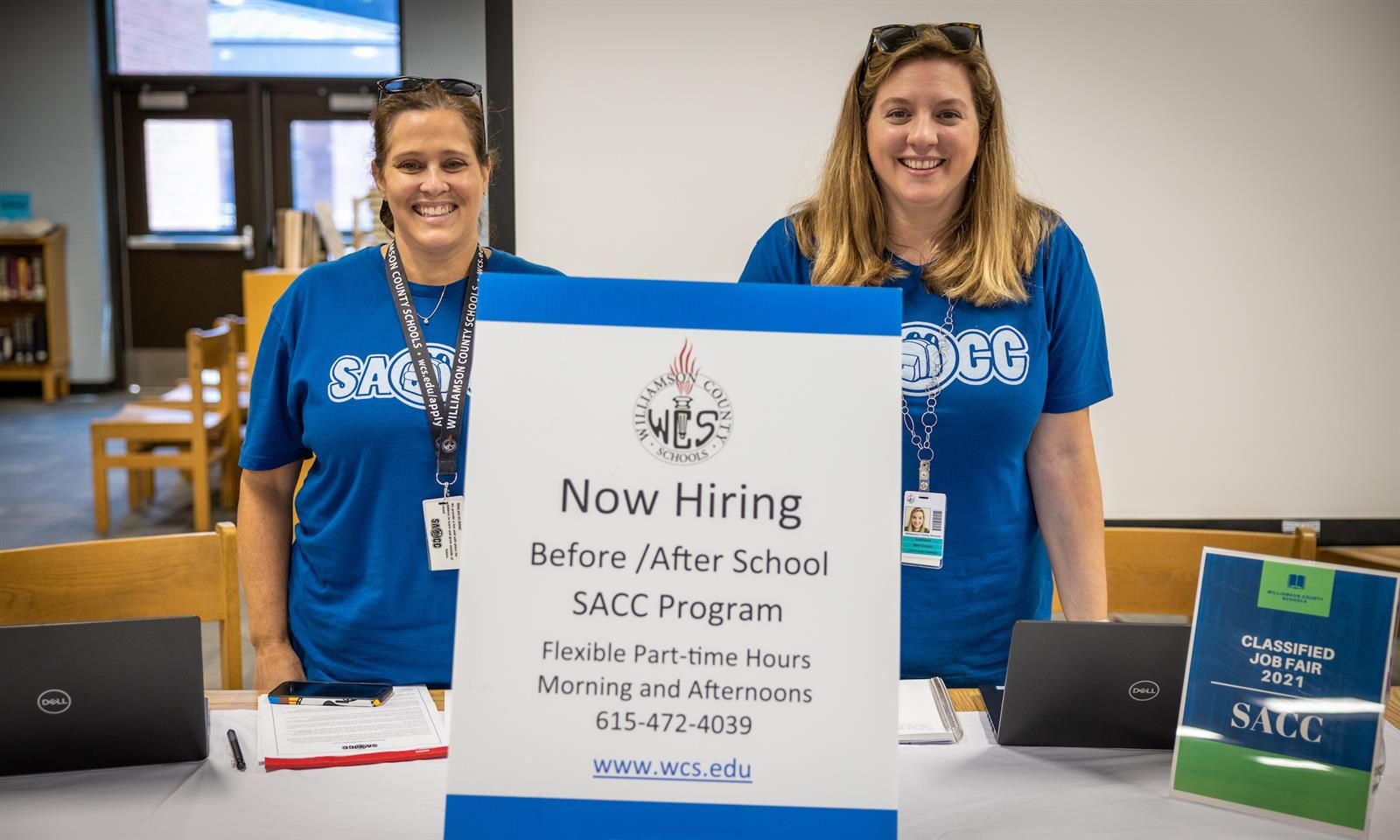 Two School Age Child Care workers smile at a Classified Career Fair